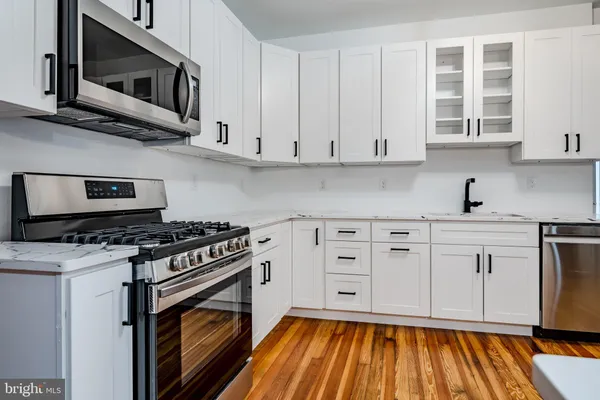 a kitchen with stainless steel appliances a stove a microwave and cabinets