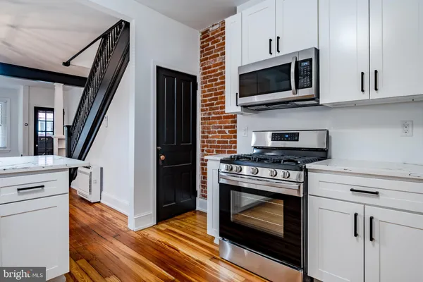 a kitchen with stainless steel appliances a stove microwave and cabinets