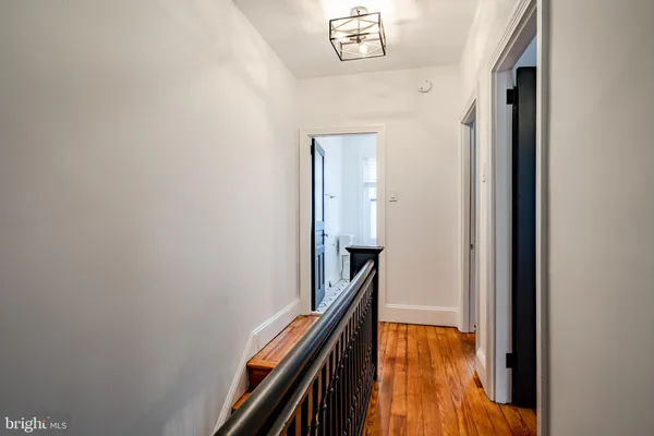 a view of a hallway with wooden floor and staircase