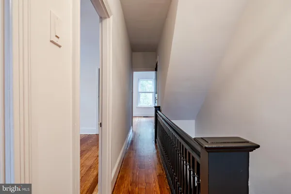 a view of a hallway with wooden floor and staircase