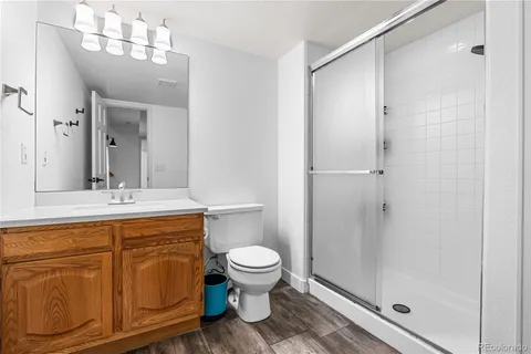a bathroom with a sink a toilet a mirror and shower
