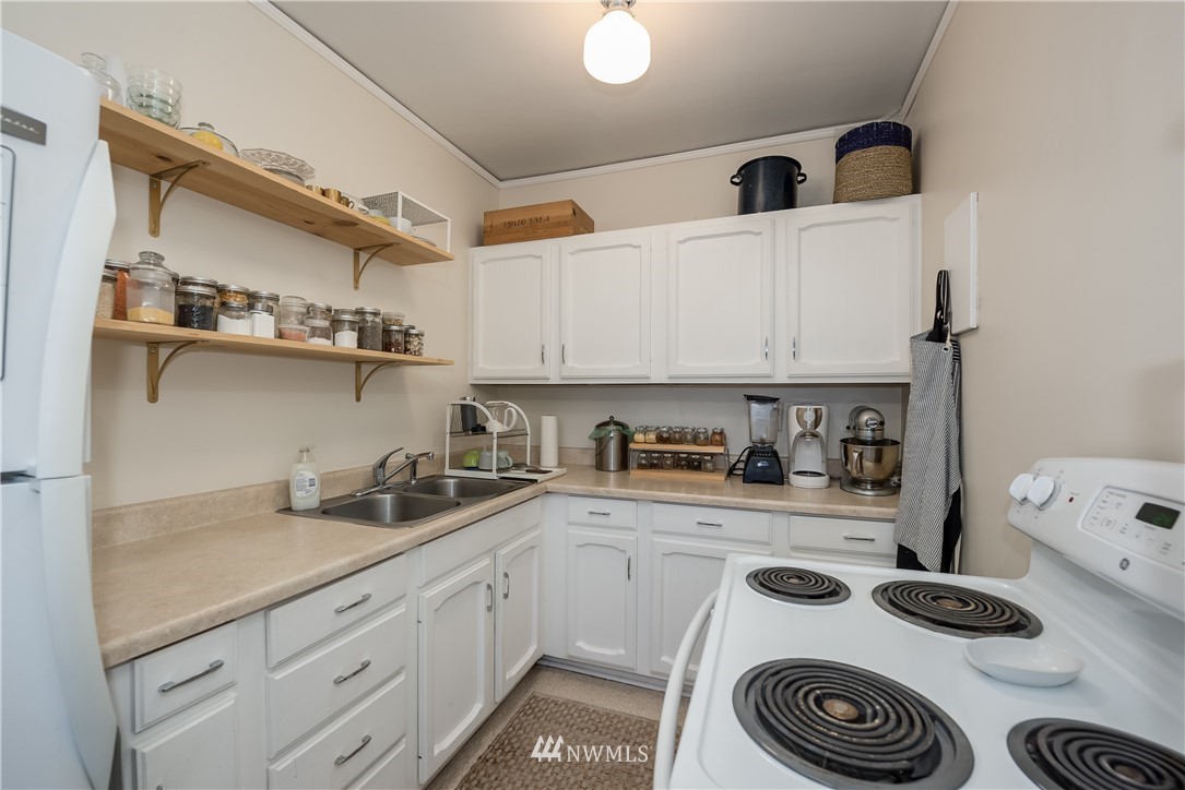 6402 Phinney Avenue North Seattle, WA 98103 - Photo 11 of 17 a kitchen with a white stove top oven and white cabinets