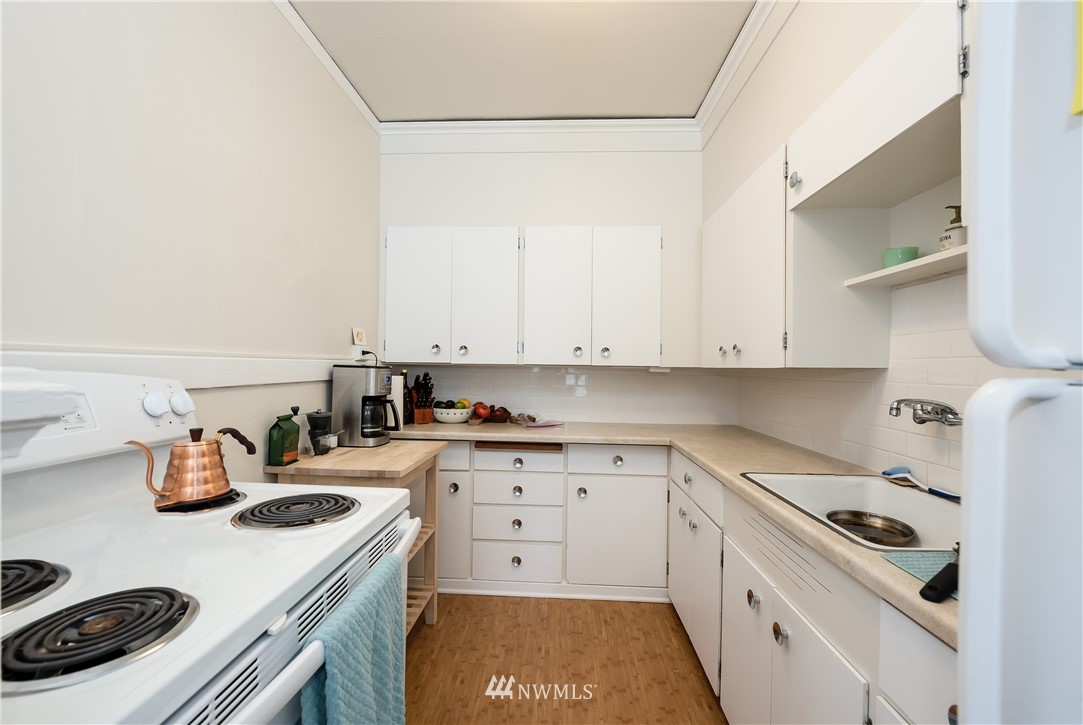 6402 Phinney Avenue North Seattle, WA 98103 - Photo 15 of 17 a kitchen with a stove a sink and a refrigerator