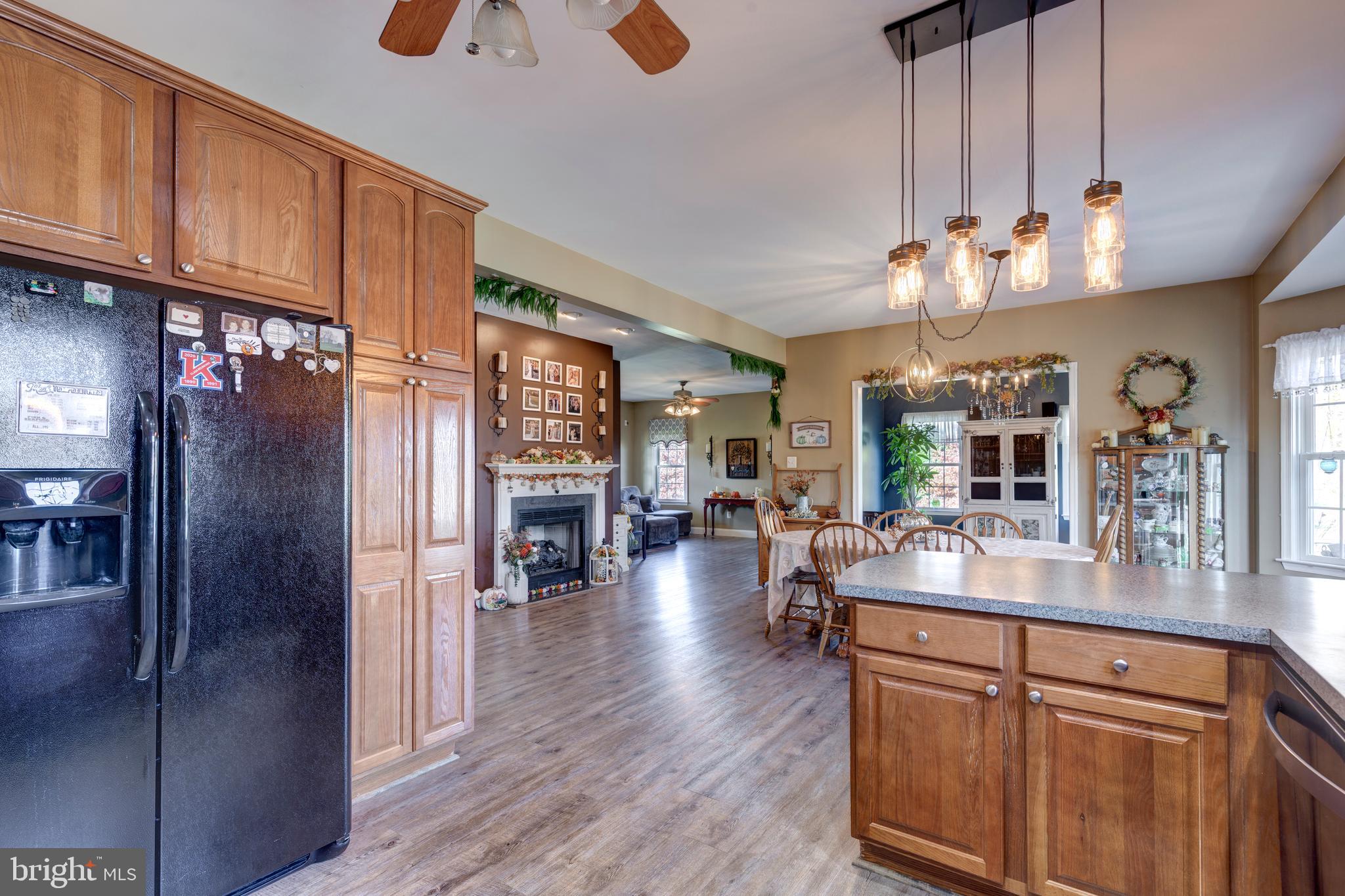 128 Pine Grove Road Hanover, PA 17331 - Photo 20 of 93 a kitchen with stainless steel appliances granite countertop a refrigerator a sink dishwasher a dining table and chairs with wooden floor