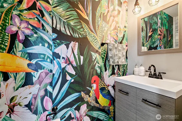 a bathroom with a sink mirror and painting on the wall
