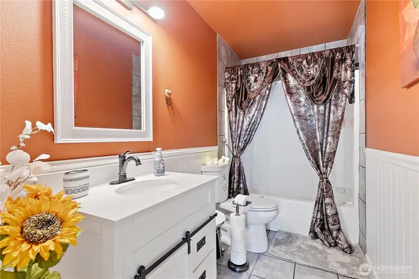 a bathroom with a sink a toilet and a mirror