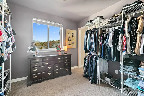 a view of walk in closet with clothes and shoes