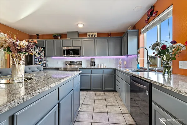 a kitchen with stainless steel appliances granite countertop a sink stove and cabinets