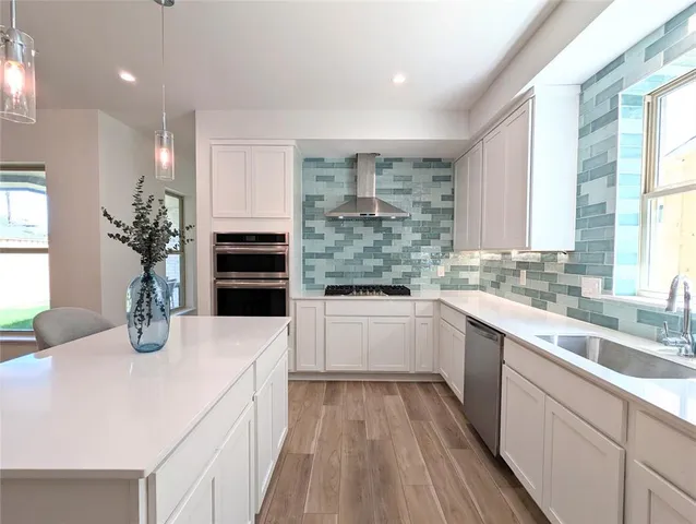 a kitchen with sink a microwave and cabinets