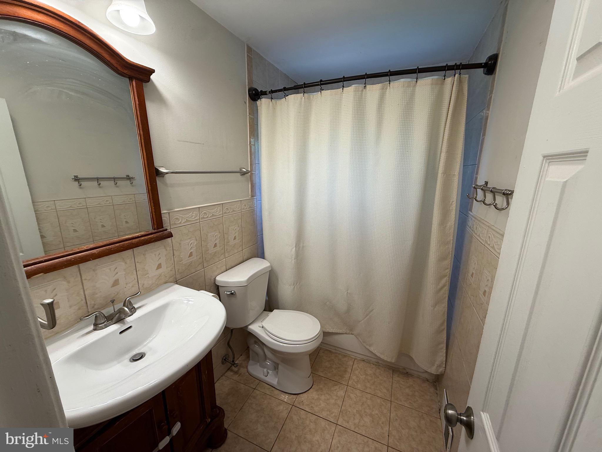 174 Kansas Road Pennsville, NJ 08070 - Photo 21 of 22 a bathroom with a sink a toilet and shower curtain