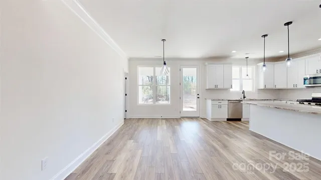 a kitchen with wooden floors and white walls