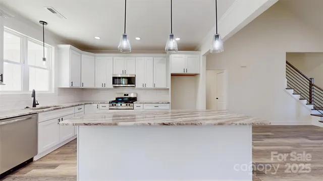 a kitchen with kitchen island a counter top space appliances and cabinets