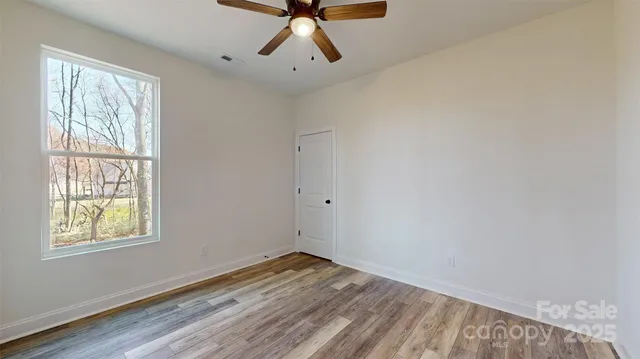 a view of a room with wooden floor and windows