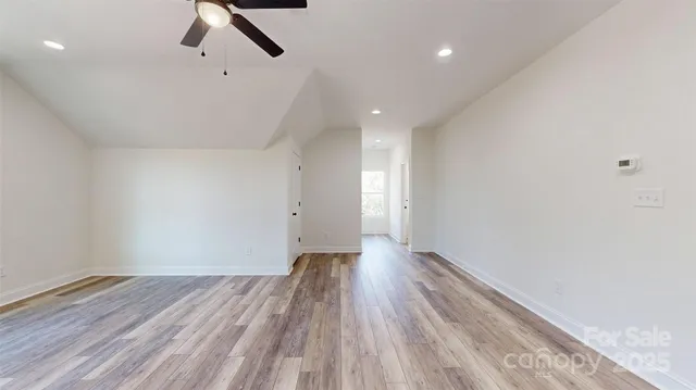 a view of room with wooden floor and windows