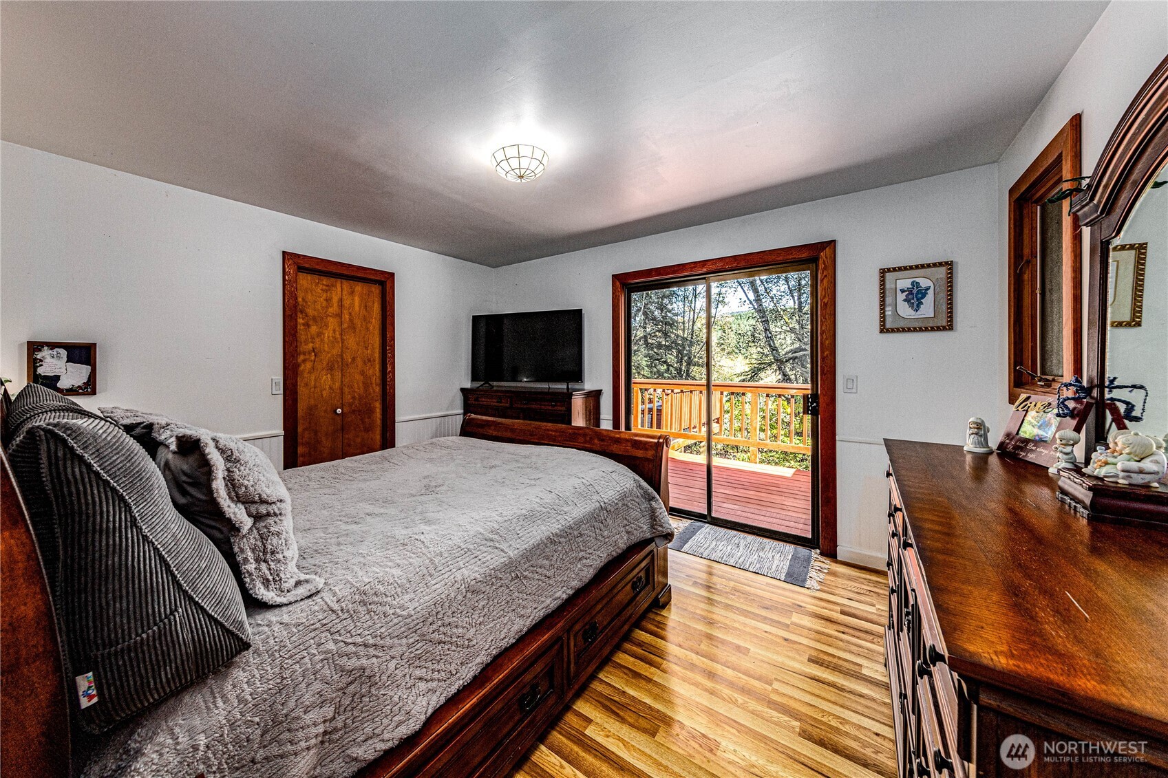 107 Dowan Creek Road Forks, WA 98331 - Photo 15 of 40 a spacious bedroom with a bed a dresser and a flat screen tv