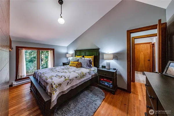 a bedroom with a bed and wooden floor