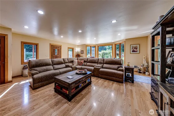 a living room with furniture a flat screen tv and a wooden floor