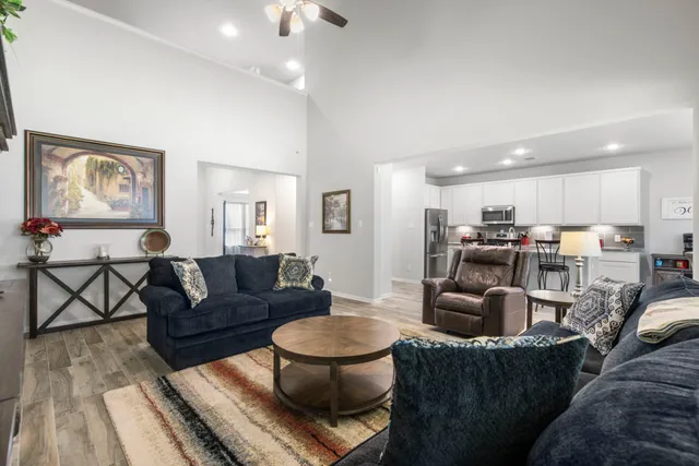 a living room with furniture and a view of kitchen
