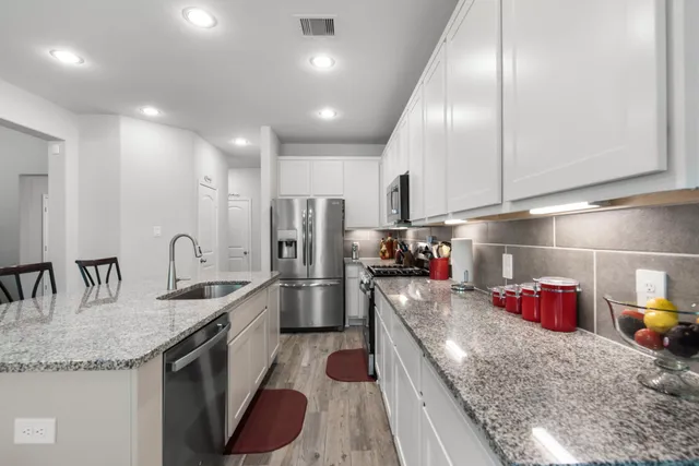 a kitchen with stainless steel appliances granite countertop a sink stove and refrigerator
