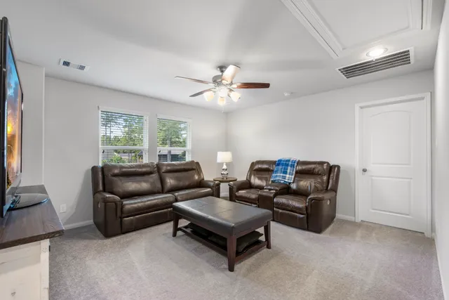 a living room with furniture and a ceiling fan