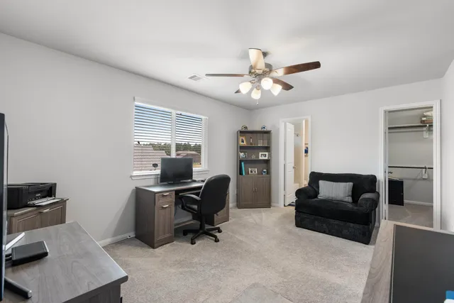 a view of a workspace with furniture and a window