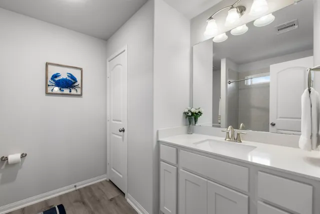 a bathroom with a sink a light fixture and a mirror