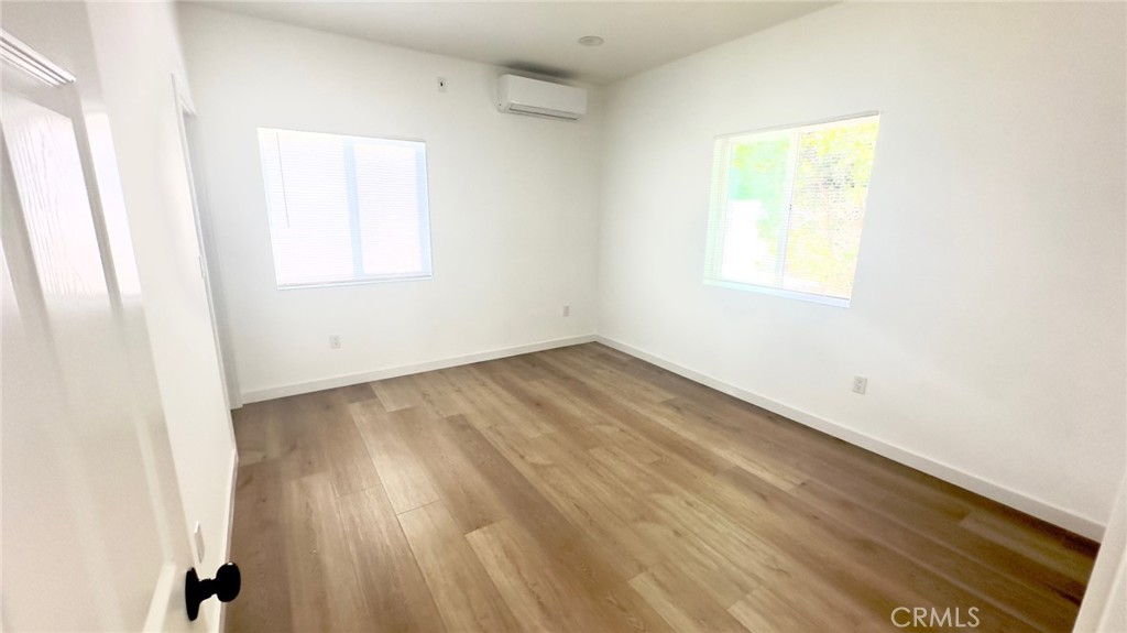 1565 1/2 Atchison Street Pasadena, CA 91104 - Photo 5 of 10 an empty room with wooden floor and windows
