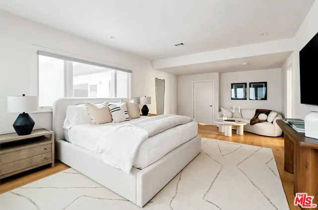 a bedroom with bed couch and window