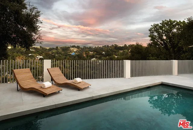 a view of swimming pool with lounge chair and lake view