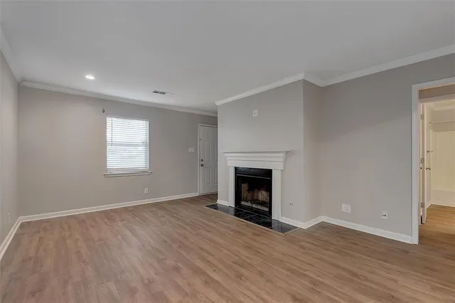 a view of empty room with wooden floor and fireplace
