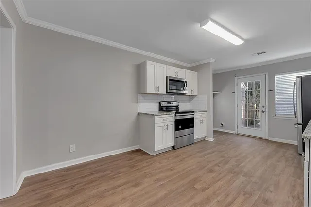 a kitchen with wooden floors and refrigerator