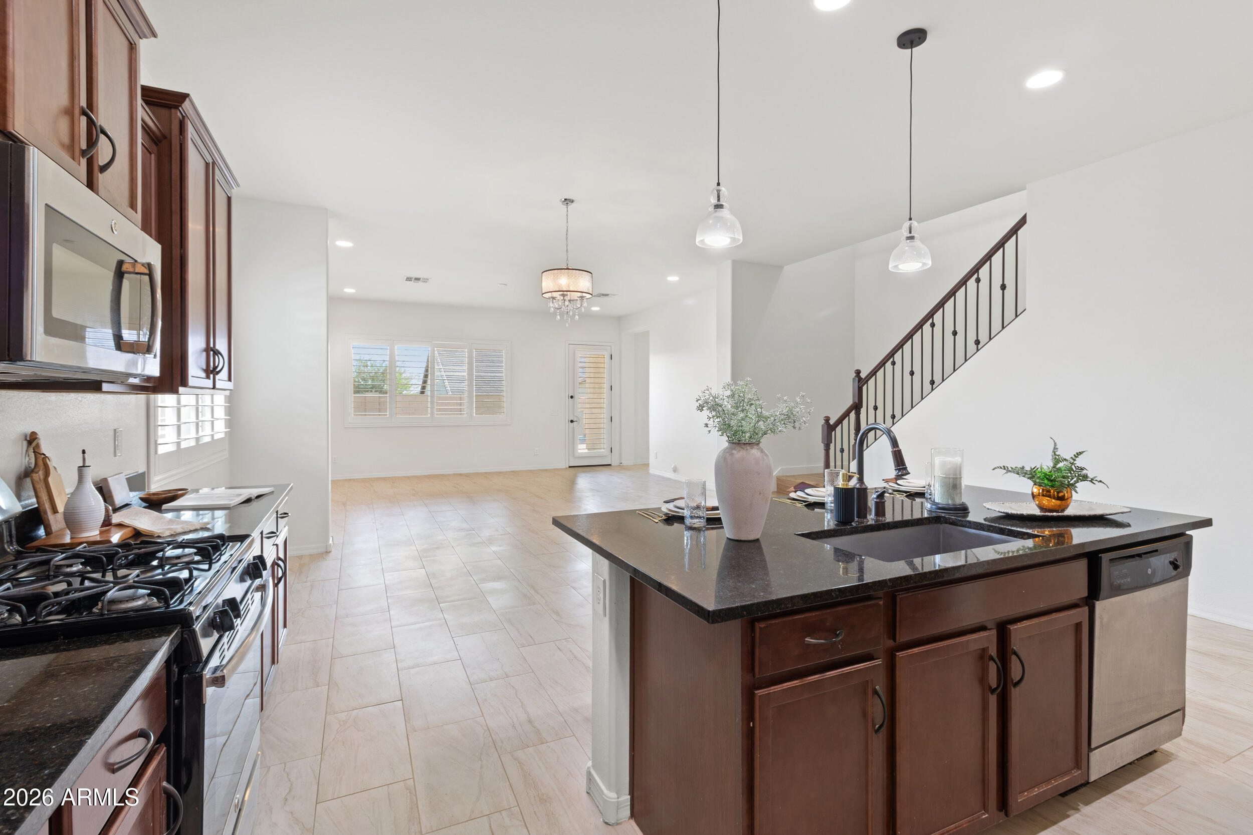 20537 West Valley View Drive Buckeye, AZ 85396 - Photo 9 of 32 a kitchen with stainless steel appliances granite countertop a sink a stove and a wooden floors