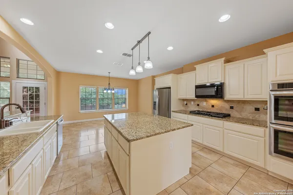 a kitchen with stainless steel appliances granite countertop a sink stove and cabinets