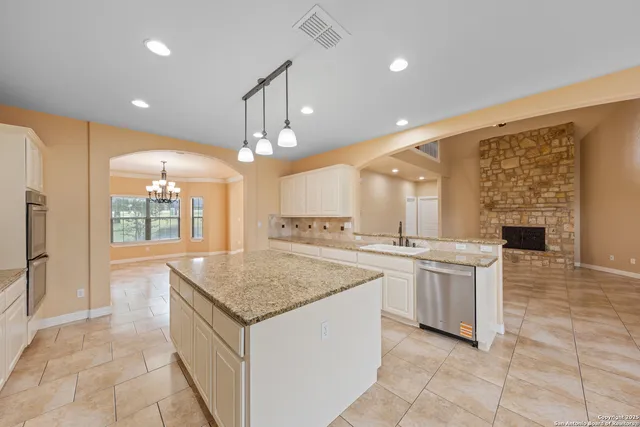 a kitchen with stainless steel appliances granite countertop a sink and a refrigerator