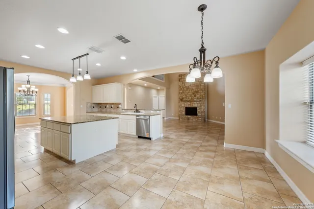a large white kitchen with a large window cabinets and stainless steel appliances