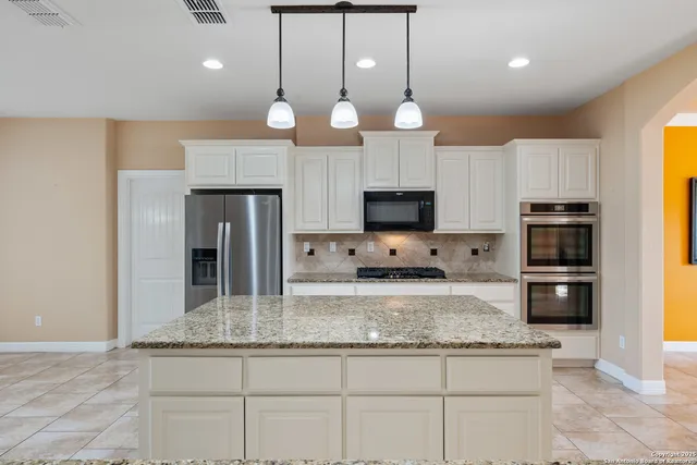 a kitchen with stainless steel appliances granite countertop a sink a stove cabinets and refrigerator
