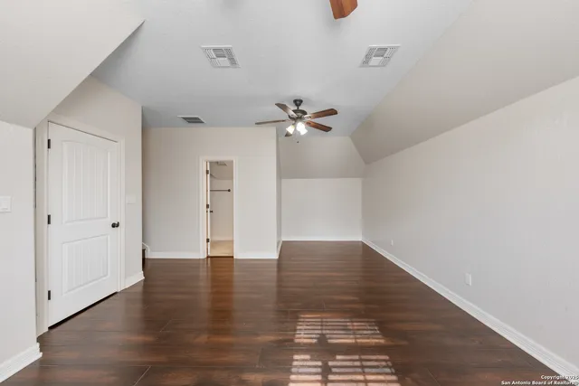 a view of an empty room with wooden floor