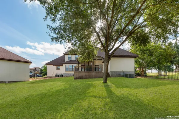 a front view of a house with a yard and trees