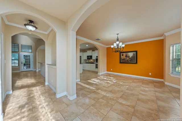a view of a hallway with wooden floor and a chandelier
