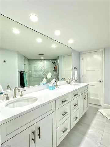 a bathroom with double sink and a large mirror