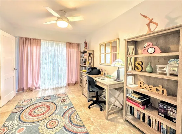 a view of a workspace with furniture and a window