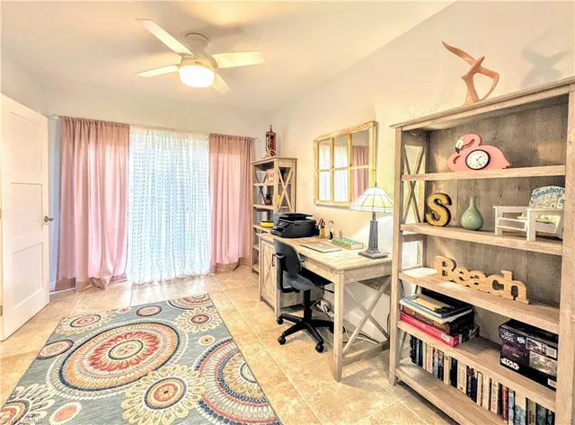 a view of a workspace with furniture and a window