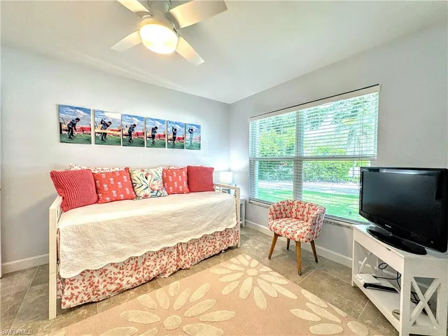 a living room with a bed furniture and a flat screen tv