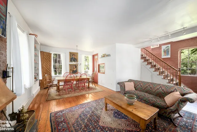 a living room with furniture potted plant and a large window