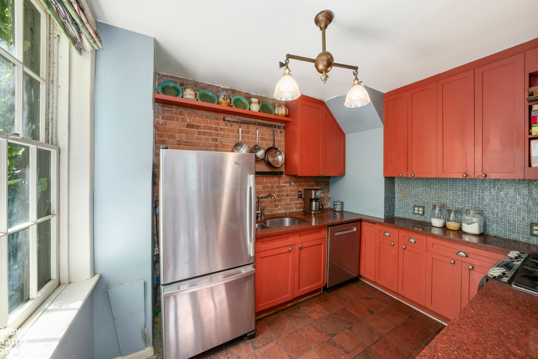 422 West 46th Street, Unit 2R Manhattan, NY 10036 - Photo 6 of 10 a kitchen with stainless steel appliances granite countertop a refrigerator a sink dishwasher a stove with wooden cabinets