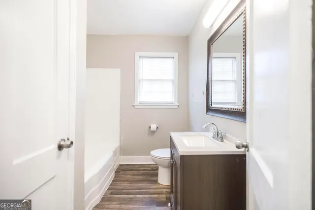 a bathroom with a sink and mirror with toilet