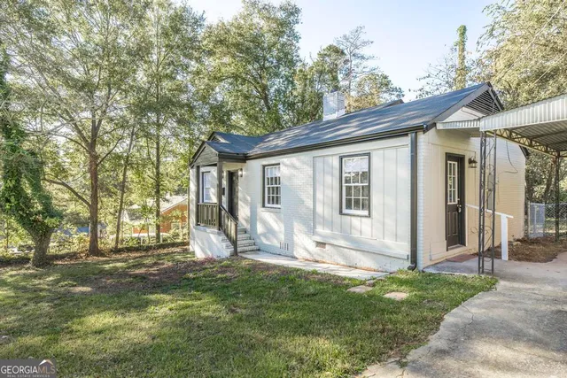 a view of a house with backyard and a tree