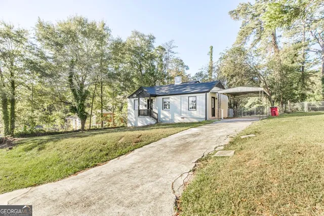 a front view of a house with a yard and trees