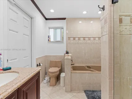 a bathroom with a granite countertop sink a toilet a mirror and shower