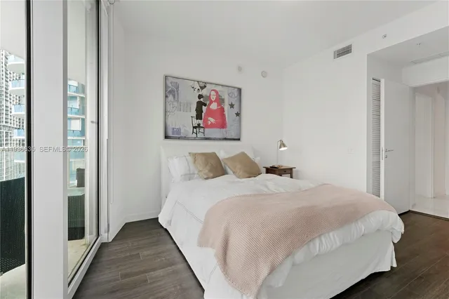 a bedroom with bed and wall painting